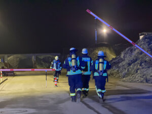 Einsatzkräfte betreten das Gelände der Glasaufbereitungsanlage. Foto: Krischi Meier 