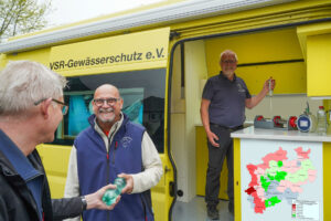 Frank Hage (mitte) und Harald Gülzow (rechts) beraten einen Bunnenbesitzer und untersuchen eine Breunnenwasserprobe, mit Nitratkate von NRW. Foto: Ruben Wiltsch
